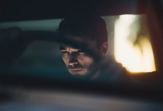 Handsome young man in automobile at twilight