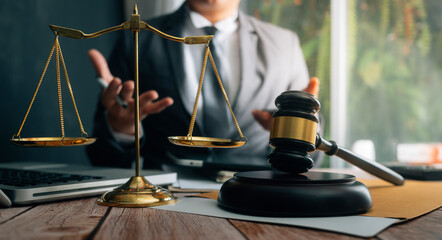 Justice and law concept.Male judge in a courtroom with the gavel, working with, computer and...