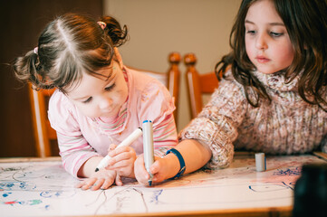 Two little girls colouring in together