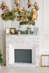 Modern marble fireplace in the living room or dining room, decorated for the New Year Christmas tree in the interior