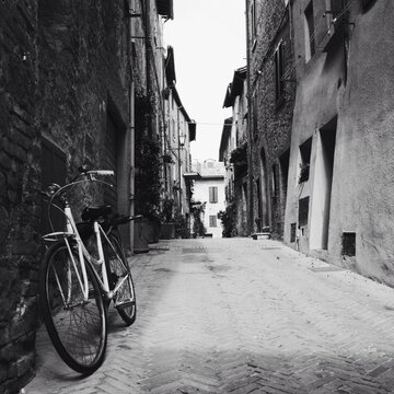Fototapeta A bicycle on a narrow street in Italy in black and white