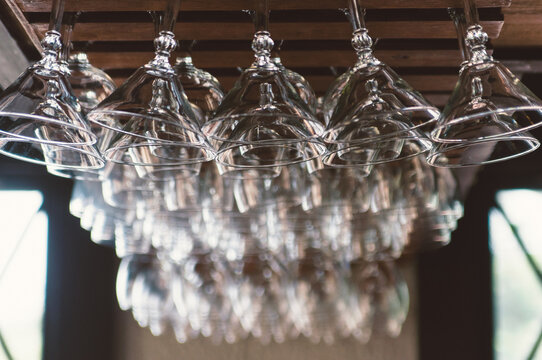 cocktail glasses hanging from the ceiling of a bar