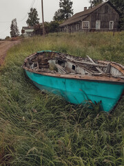 Wooden boat on the shore of Shuya and a view of the village. Old wooden house in the background. Russia.