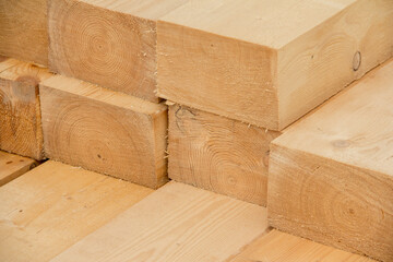 Piled wooden beams. Closeup big wooden boards. Stacked wooden beams of square section for house construction