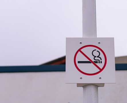 Se&ntilde;al de prohibido fumar sujeta en un poste blanco