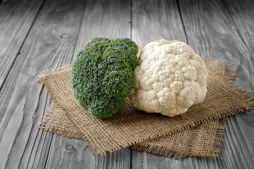 Fresh cauliflower and broccoli on grey wooden table