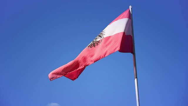 Austrian flag waving in the wind on sunny day against blue sky Austria. Flag theme