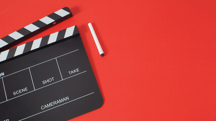 Fototapeta na wymiar Pen with black Clapperboard or movie slate use in film production and cinema industry on red background.