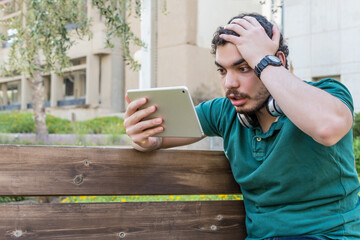 Worried man, checking tablet