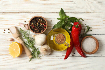 Different spices and herbs on white wooden background, top view