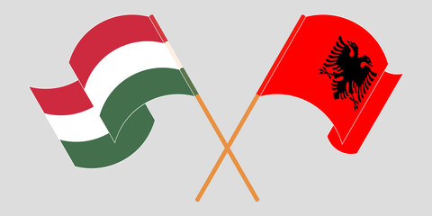 Crossed and waving flags of Albania and Hungary