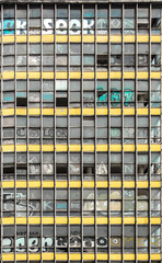 Fachada de edificio abandonado en la Ciudad de México, detalle de ventanas, cancelería y pintura desgastada. Captura vertical. 