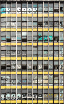Fachada de edificio abandonado en la Ciudad de M&eacute;xico, detalle de ventanas, canceler&iacute;a y pintura desgastada. Captura vertical. 