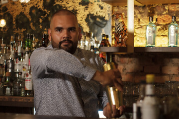 Primer plano de Barman Cantinero mexicano profesional preparando un cóctel alcohólico para los...