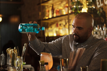 Barman Cantinero mexicano profesional preparando un cóctel alcohólico para los clientes en el bar o discoteca