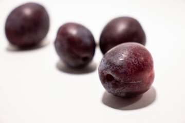 Purple plums on white background