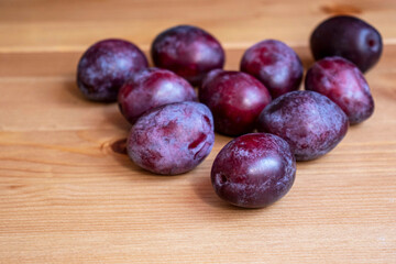 Purple plums on a wooden table