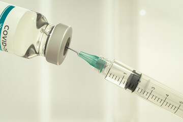 Close up of a coronavirus vaccine bottle with syringe.