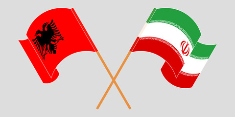 Crossed and waving flags of Albania and Iran