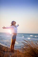 Joven disfrutando del atardecer en la playa