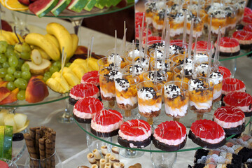cakes, fruits, berries and desserts at the buffet table.