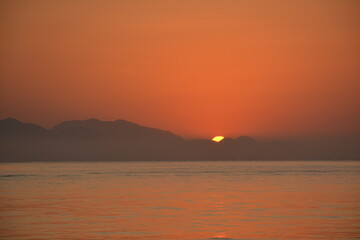 Sunrise in Ubatuba, Brasil. exact moment when the sun rises in the mountains and reflects in the sea