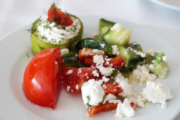 tomato, zucchini and bell pepper with feta cheese on a white plate