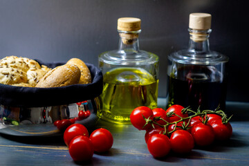 Tomaten mit Essig und Öl und Brotkörbchen aus Metall