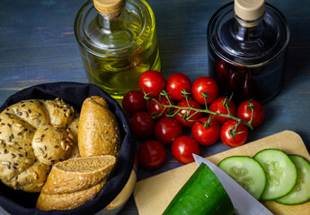 Veganes Essen mit Gurke, Tomaten, Brötchen und Öl und Essig