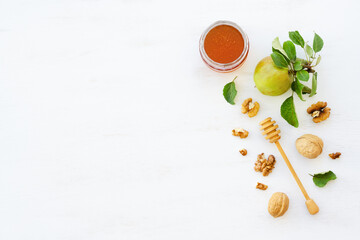 Honey, apples and walnuts on white wooden background