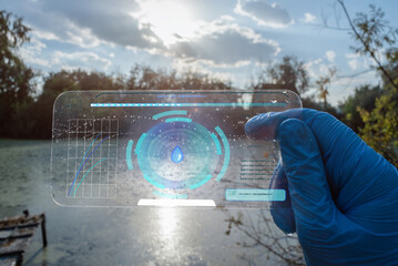 A scientist is analysing a water pollution in the pond by sci fi digital scanner concept.