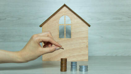 A woman's hand accumulates a penny to buy a house