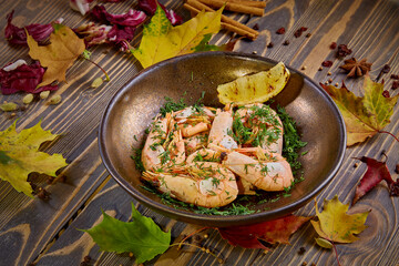 Fototapeta na wymiar Boiled prawns with lemon and dill are on a plate