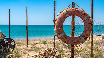 An old lifeline against the sea hangs on the beach all broken