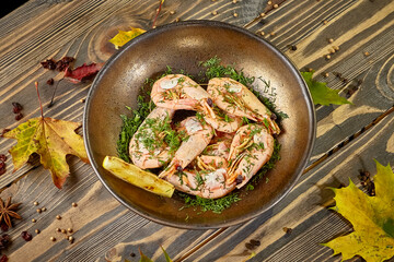 Boiled prawns with lemon and dill are on a plate