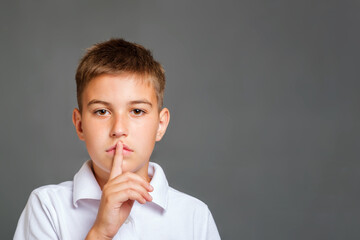 kid asking to be quiet with finger on lips. Copy space for text