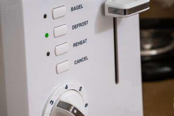 Close up of the controls on the front of a toaster on a kitchen counter