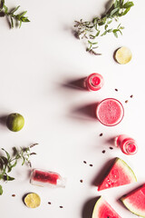 Tasty summer watermelon drink in bottle and slices of fresh fruits on white background