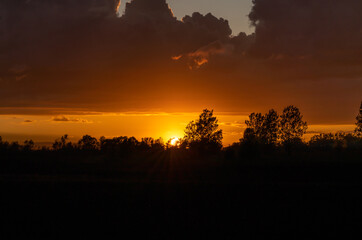 Fototapeta na wymiar Sunset illuminating dark storm clouds.