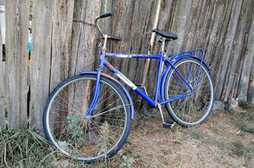 Fototapeta na wymiar Old rusty vintage bicycle near the concrete wall