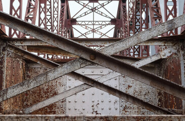 Part of old steel construction of bridge, construction details with metal girders, bolts and nuts.