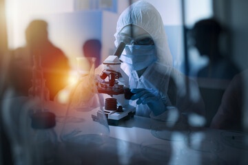 Doctor in the laboratory analyzes samples under a microscope. Pharmaceutical treatment concept.