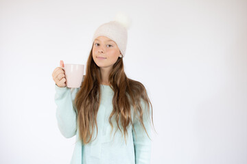 Smiling beautiful girl in winter clothes with a cup