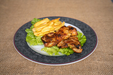 Chicken served with fried potatoes and lettuce