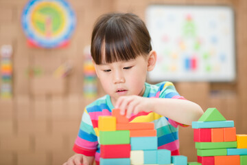  young girl playing creative toy blocks for homeschooling