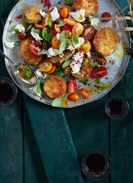 Overhead view of crispy eggplant salad with tomatoes and burrata cheese