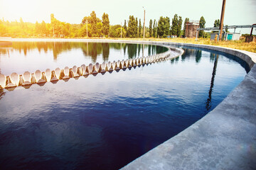 Obraz premium Modern urban wastewater treatment plant reservoir in sunlight