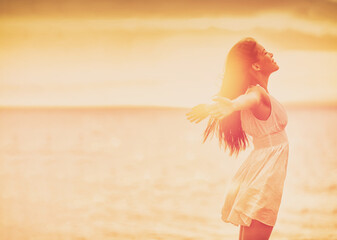 Wellness woman feeling free with open arms in freedom side profile silhouette on ocean beach...