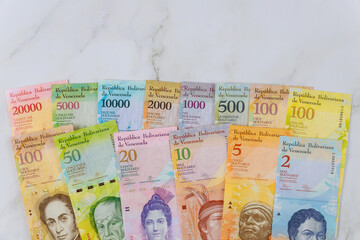 Venezuelan Bolivar banknote with paper currency bills. - obrazy, fototapety, plakaty