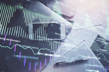 Multi exposure of forex graph hologram over desktop with phone. Top view. Mobile trade platform concept.